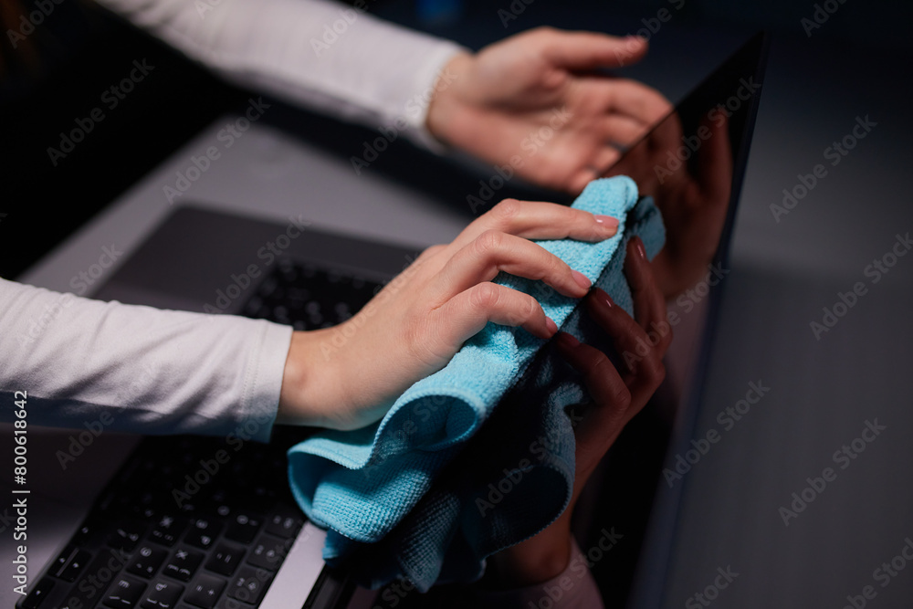 Cleaning the screen of laptop computer with microfiber cloth by hand