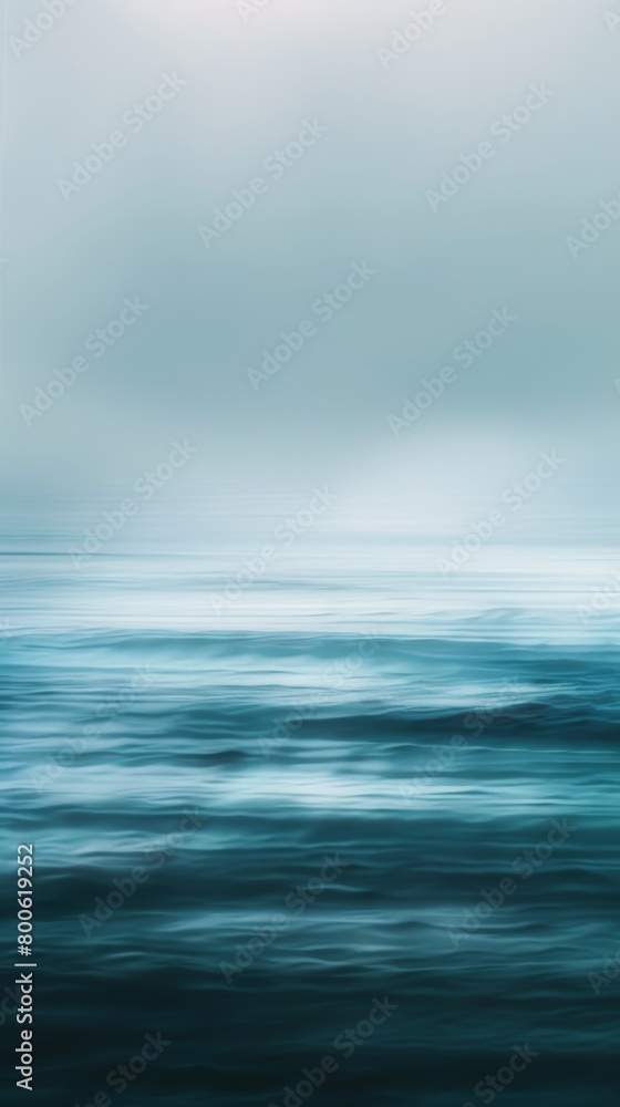 A blurry image of a body of water with a pinkish hue. The water appears to be calm and peaceful, with no visible movement. The sky above the water is a light blue color