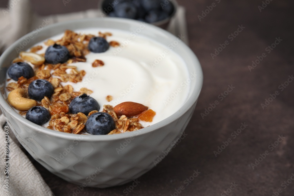 Bowl with yogurt, blueberries and granola on grey table, closeup. Space for text Bowl with yogurt, blueberries and granola on grey table, closeup. Space for text