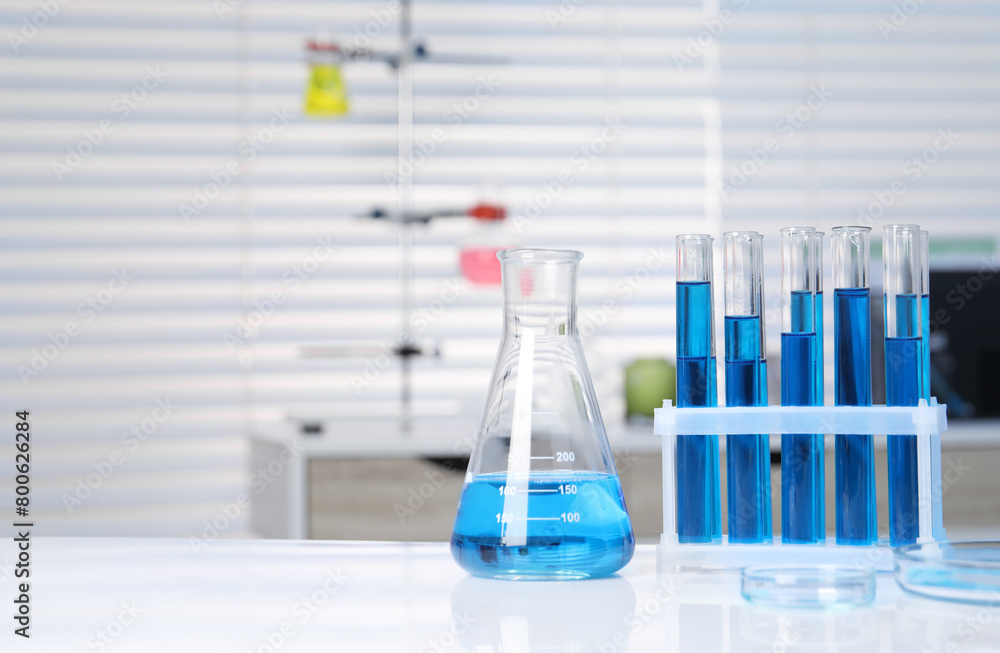 Laboratory analysis. Different glassware with blue liquid on white table indoors Laboratory analysis. Different glassware with blue liquid on white table indoors