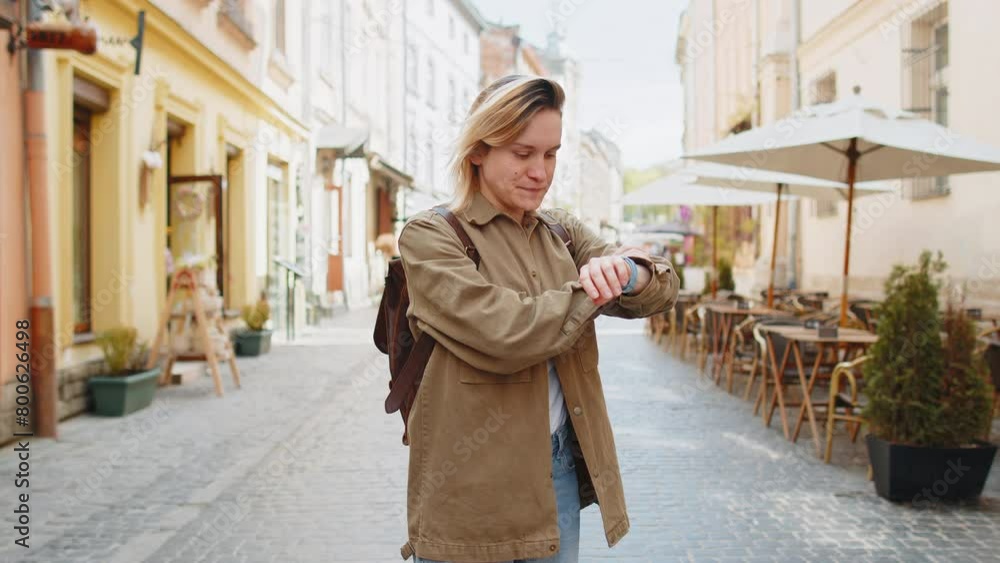 Scared woman worrying to be punctual, with anxiety checking time on watch, running late to work or transport, being in delay, deadline outdoors. Girl tourist running on city street. Town lifestyles. Scared woman worrying to be punctual, with anxiety checking time on watch, running late to work or transport, being in delay, deadline outdoors. Girl tourist running on city street. Town lifestyles.