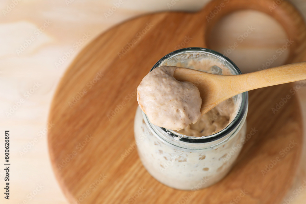 Taking fresh sourdough with spoon at table, closeup. Space for text Taking fresh sourdough with spoon at table, closeup. Space for text