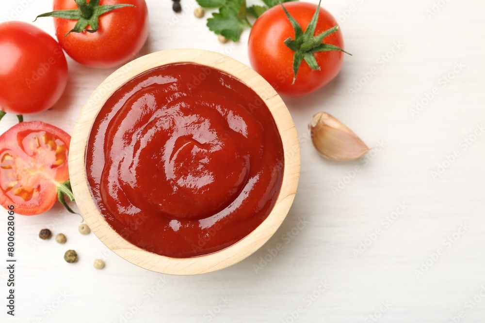 Delicious ketchup in bowl, peppercorns and tomatoes on white wooden table, flat lay. Space for text Delicious ketchup in bowl, peppercorns and tomatoes on white wooden table, flat lay. Space for text