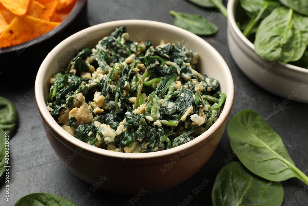 Tasty spinach dip with egg in bowl on black table, closeup Tasty spinach dip with egg in bowl on black table, closeup
