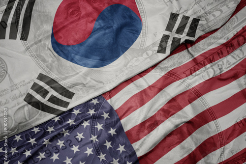 waving colorful flag of united states of america and national flag of south korea on the dollar money background. finance concept. photo