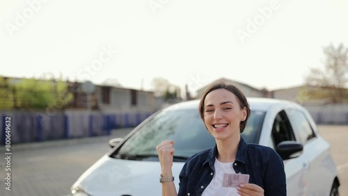 A woman reacts emotionally to her new driver's license. Driving school concept