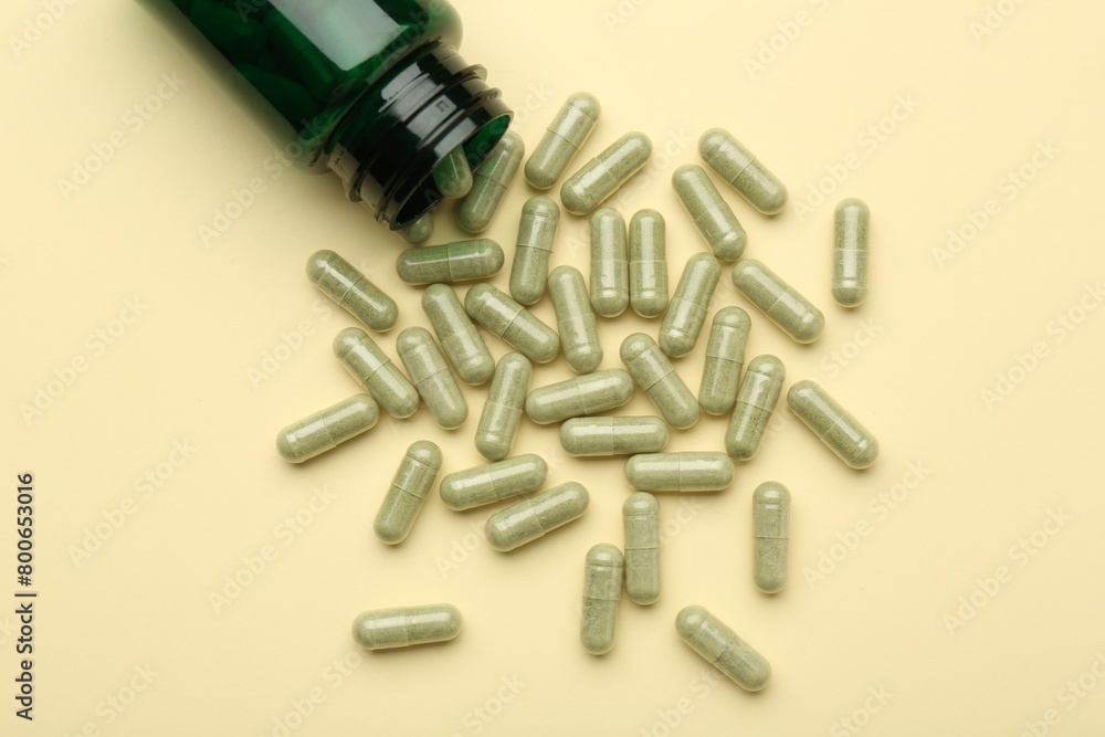 Vitamin pills and bottle on beige background, top view Vitamin pills and bottle on beige background, top view