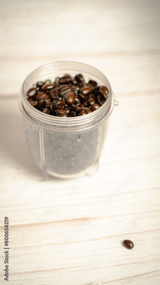 A bullet mixer jar filled with French roast coffee beans, ready for grinding. A bullet mixer jar filled with French roast coffee beans, ready for grinding.
