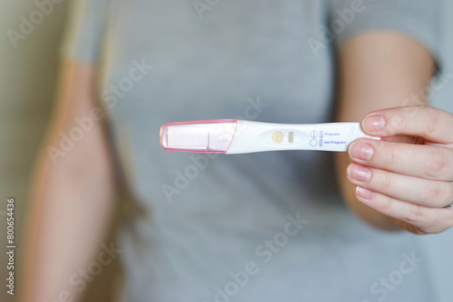 Close up of a woman holding a negative pregnancy test