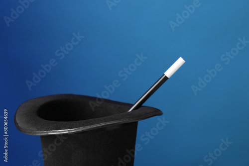 Magician's hat and wand on blue background