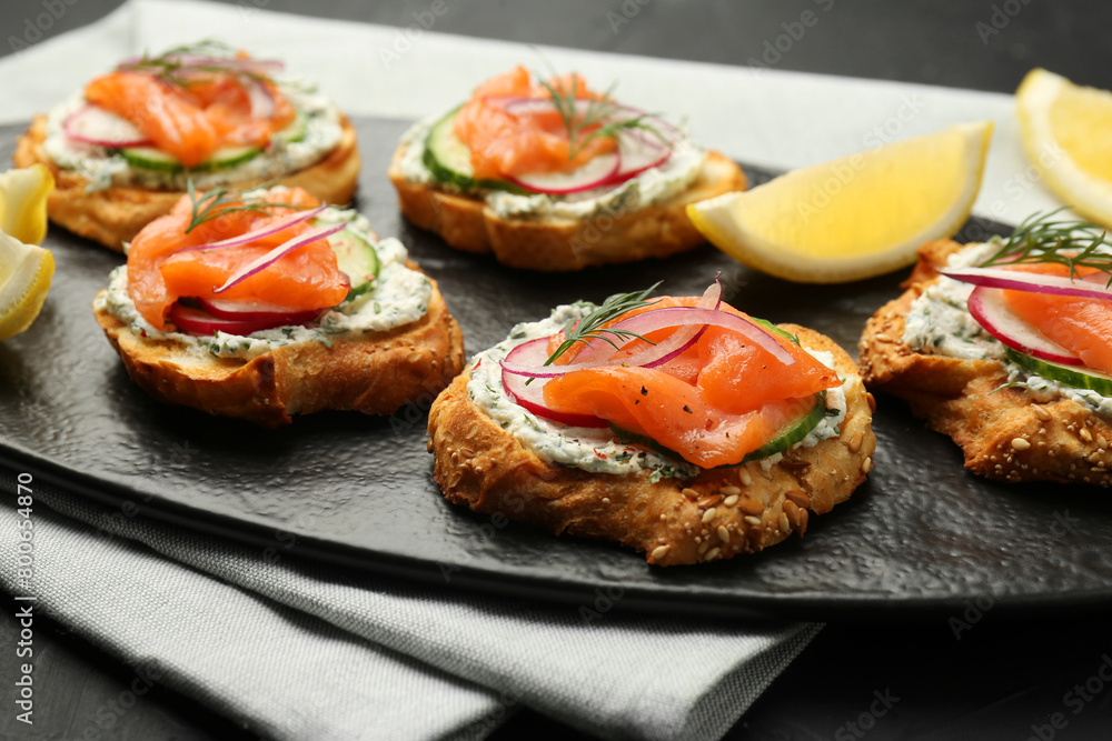 Tasty canapes with salmon, cucumber, radish and cream cheese on table, closeup Tasty canapes with salmon, cucumber, radish and cream cheese on table, closeup