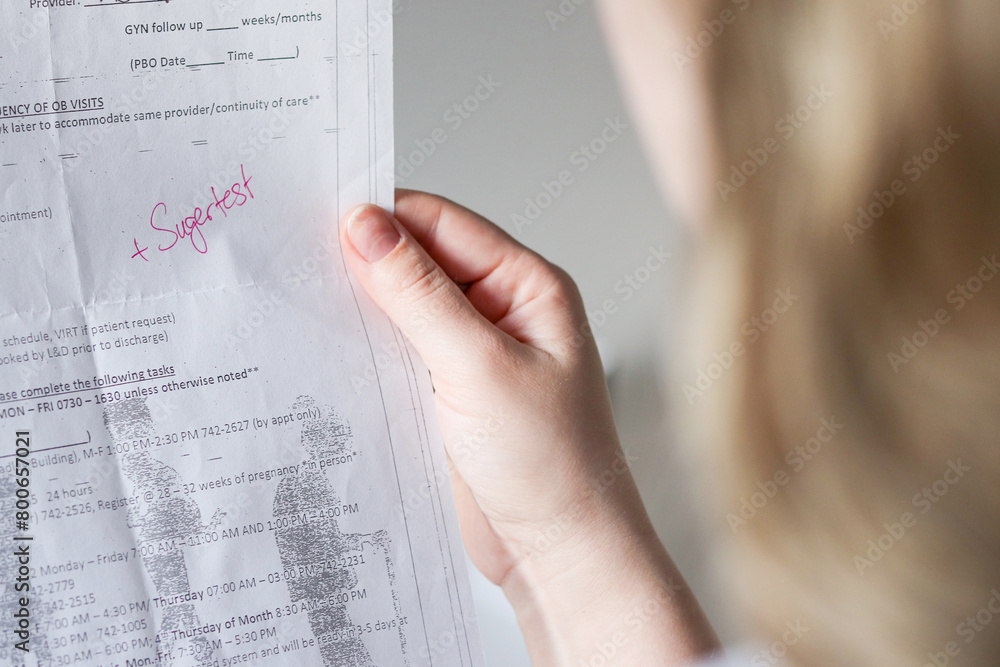 Obraz premium Close up of a woman holding a pregnancy check-up application document for blood sugar test