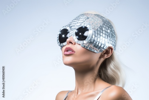 The model flaunts reflective sunglasses and a headpiece with tiny mirrored tiles, creating a futuristic and glamorous look. Her gaze averts the camera, enhancing the allure. photo