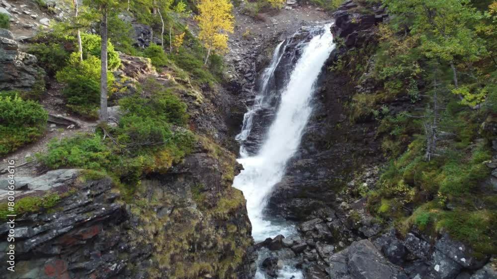 A beautiful waterfall in the autumn mountains beyond the Arctic Circle in the north, in Khibiny, Murmansk region. Panoramic view of a beautiful waterfall in the mountains in autumn, Kola Peninsula 4К A beautiful waterfall in the autumn mountains beyond the Arctic Circle in the north, in Khibiny, Murmansk region. Panoramic view of a beautiful waterfall in the mountains in autumn, Kola Peninsula 4К