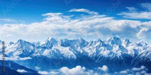 Majestic snow-capped mountain peaks against a blue sky © Balaraw