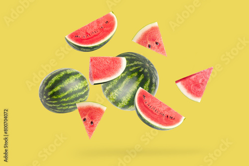 Falling watermelon on yellow background photo