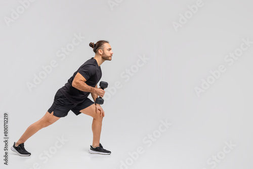 Man in Black Shirt and Shorts Holding a Dumbbell © Prostock-studio