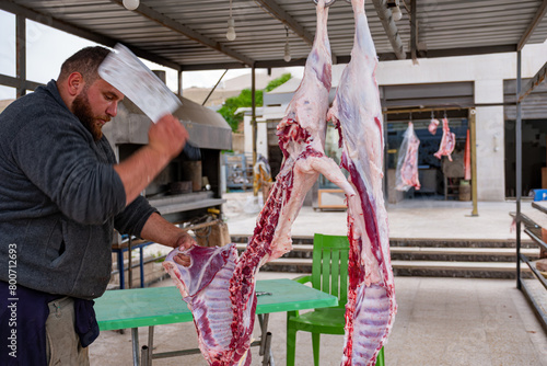 Bearded man cutting meat for poor peoples during eid in butchery © nooh