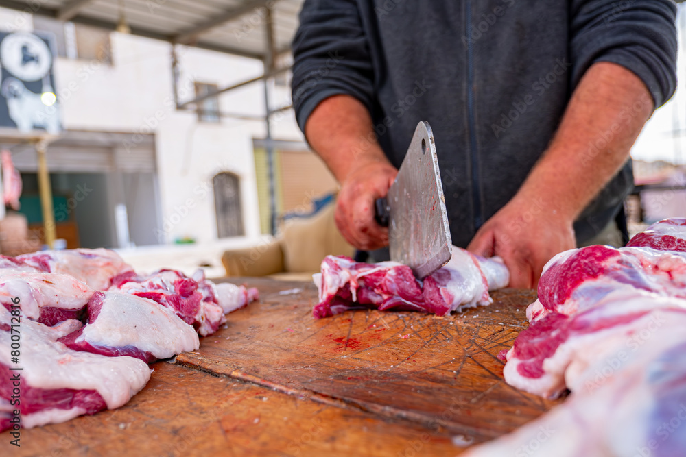 A man with a focused expression carefully slices through a piece of meat on a sturdy wooden cutting board. Each deliberate motion of his knife reflects years of practiced skill A man with a focused expression carefully slices through a piece of meat on a sturdy wooden cutting board. Each deliberate motion of his knife reflects years of practiced skill