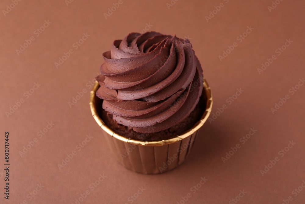 Delicious chocolate cupcake on brown background, closeup Delicious chocolate cupcake on brown background, closeup