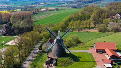 Aerial drone view of ancient windmill with agricultural fields in background in German countryside