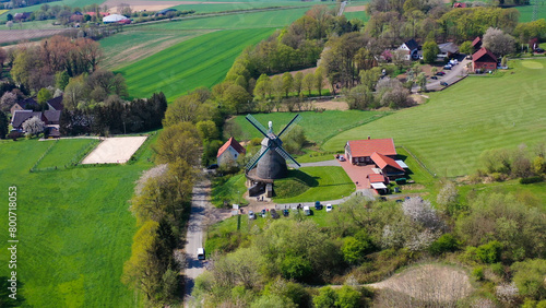 Aerial drone view of ancient windmill with agricultural fields in background in German countryside