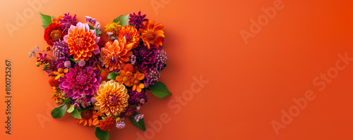 heart shaped floral wreath against an orange background with copyspace