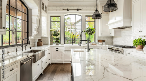 A large kitchen with a marble countertop and white cabinets. The kitchen is well-lit and has a modern feel