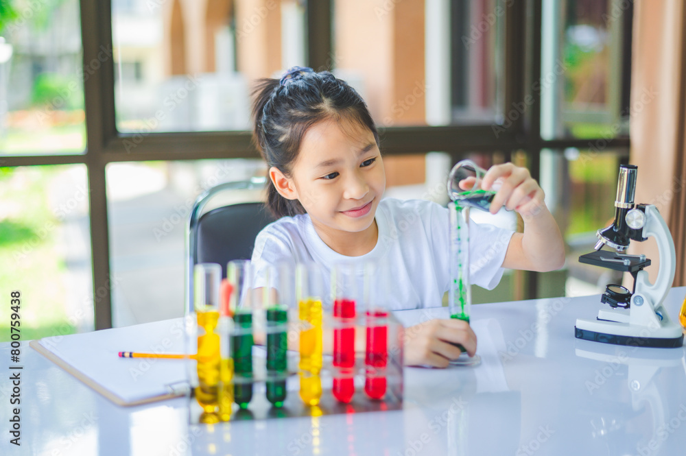 little scientist looking through a microscope and test tubes filled with chemicals for learning about science and experiments. little scientist looking through a microscope and test tubes filled with chemicals for learning about science and experiments.