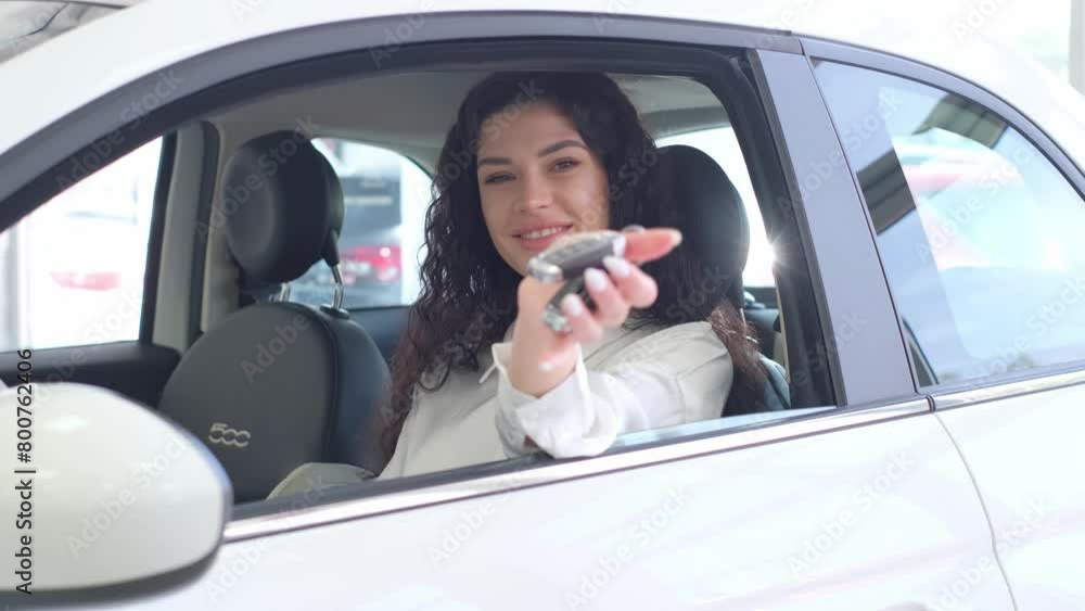 Satisfied dark-skinned woman bought a new car and shows car keys. Satisfied dark-skinned woman bought a new car and shows car keys.