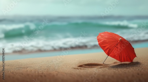  a red cocktail umbrella in the sand photo