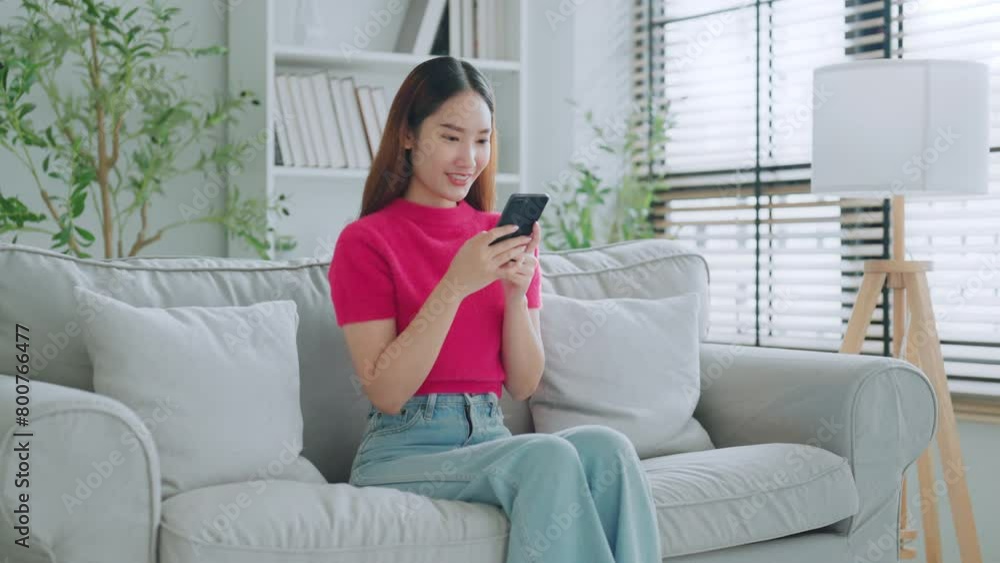 Happy young asian woman relax on comfortable couch at home texting messaging on smartphone, smiling girl use cellphone chatting, online shopping at home, video call communication Happy young asian woman relax on comfortable couch at home texting messaging on smartphone, smiling girl use cellphone chatting, online shopping at home, video call communication