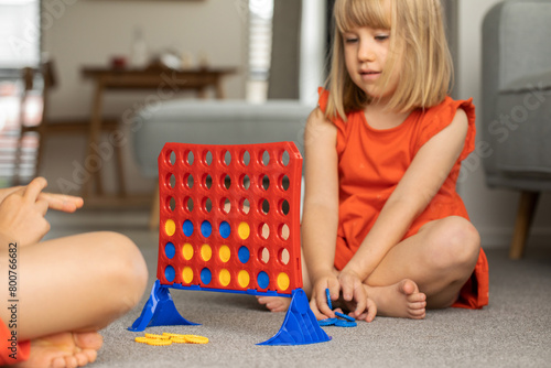 Cute little girl strategizing in Connect Four. Logic game