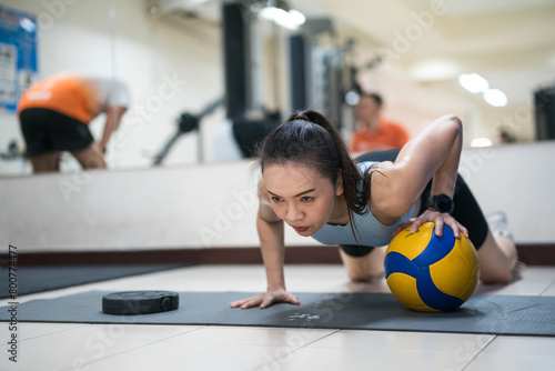 An adult woman works out in the gym. A beautiful Asian woman working out in the gymnasium. 