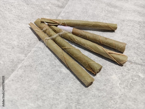 Bidi or Beedi, A beedi is a thin cigarette or mini-cigar filled with tobacco flake and commonly wrapped in a tendu or Piliostigma racemosum leaf tied with a string or adhesive, bidi isolated 