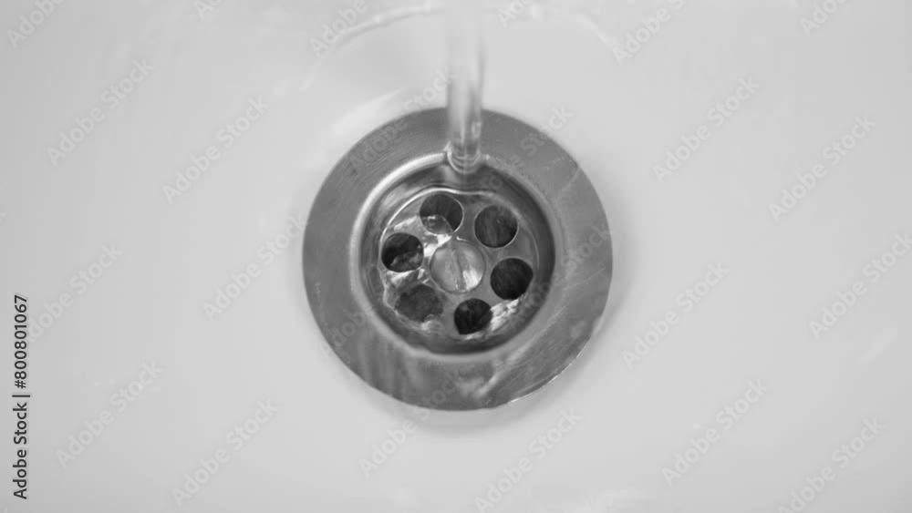 Water is running into white sink at bathroom, closeup Water is running into white sink at bathroom, closeup