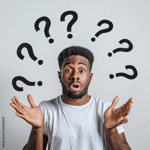 a man standind looking very confused with question marks flying over his head