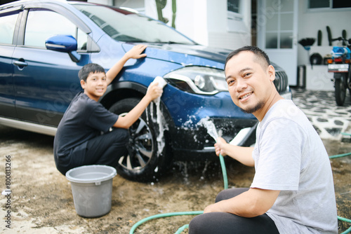 Portrait of Father and Son Smiling at Camera While Washing Car Outdise The House 