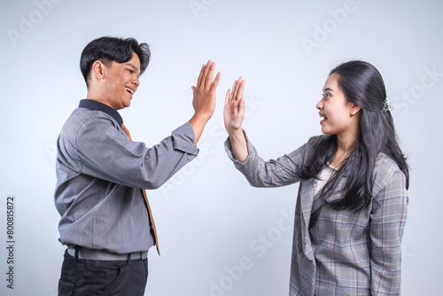 Young Businessman and Businesswoman Making High Five, Celebrating Achievement as a Solid Team at The Office 
