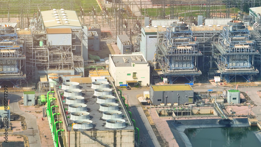 Fototapeta premium A mesmerizing aerial vista of a sprawling power plant, its colossal turbines humming with energy, surrounded by a labyrinth of steel and concrete. 
