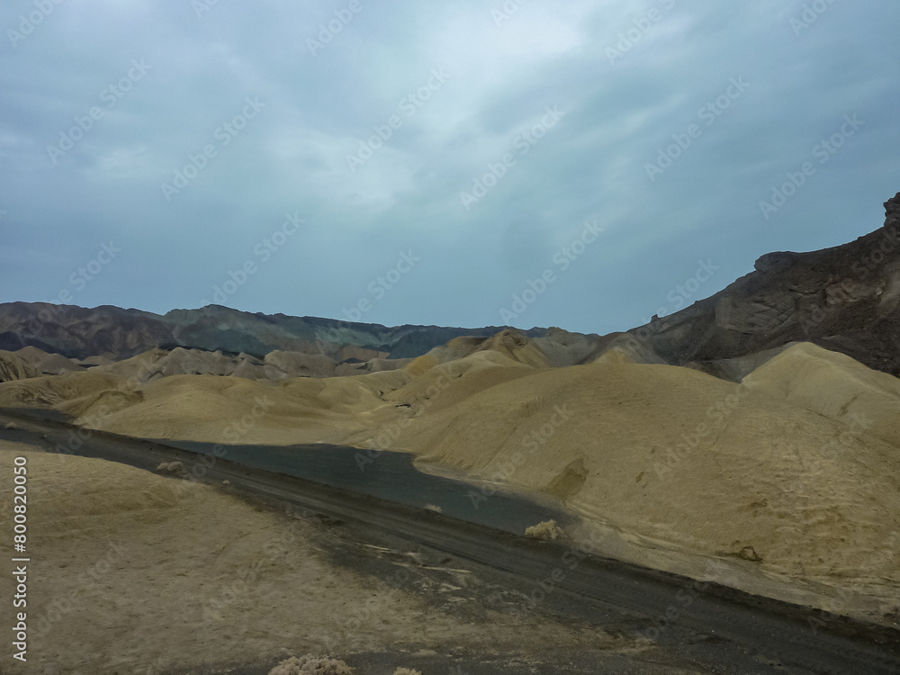 Scenic view of Badlands of Zabriskie Point, Furnace creek, Death Valley National Park, California, USA. Erosional landscape of multi hued Amargosa Chaos rock formations, Panamint Range in the back Scenic view of Badlands of Zabriskie Point, Furnace creek, Death Valley National Park, California, USA. Erosional landscape of multi hued Amargosa Chaos rock formations, Panamint Range in the back