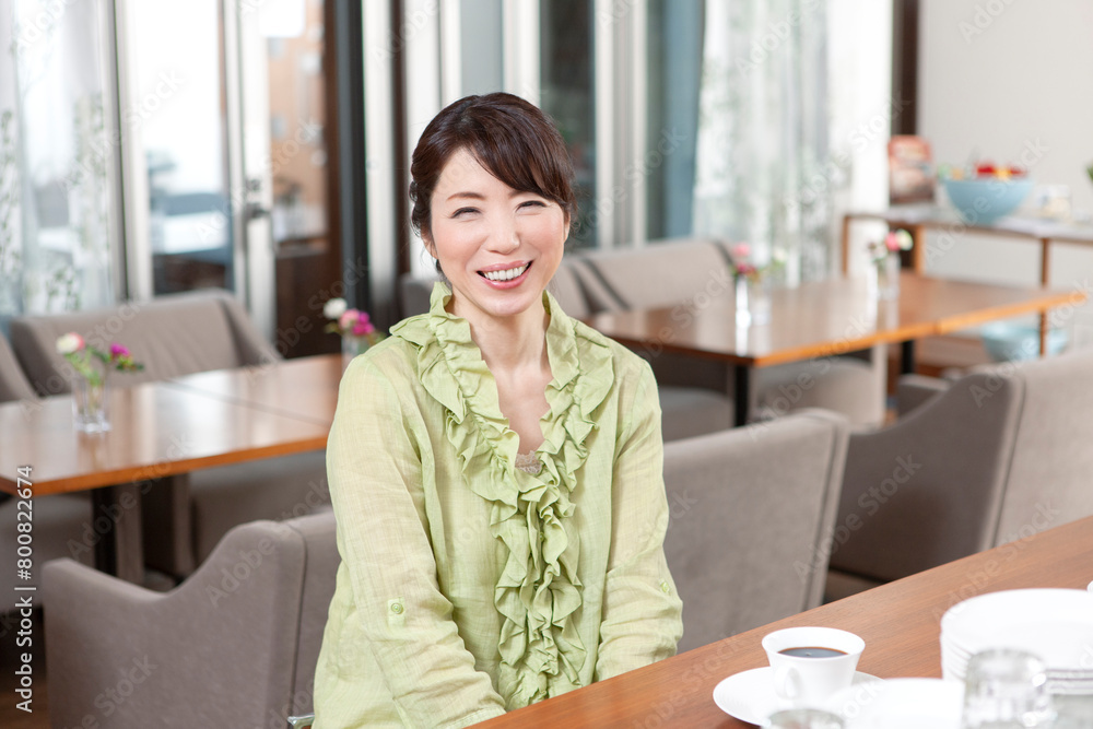 カフェにカウンターに座る中年女性