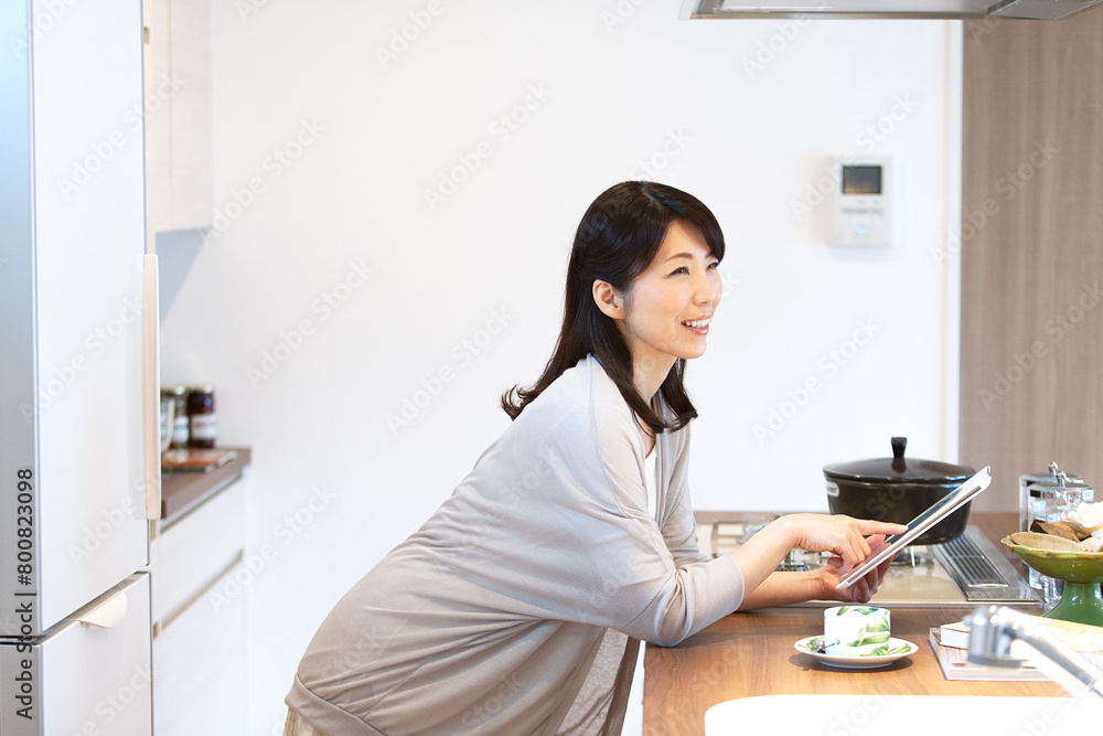 タブレットPCを持った中年女性 タブレットPCを持った中年女性