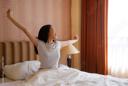 Wallpaper Mural Asian Woman stretching hands in bed after wake up in the morning Torontodigital.ca