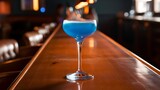 Glass with blue cocktail on a bar