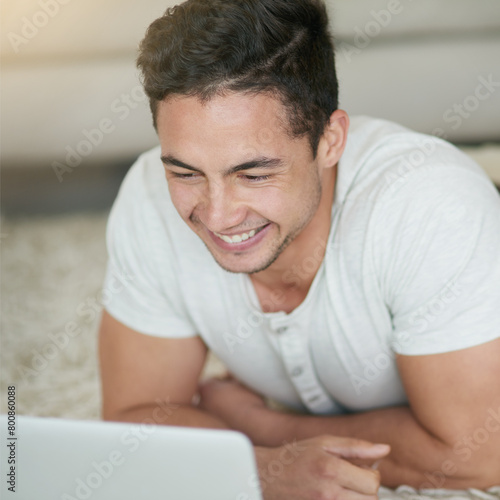Man, laptop and student for course in home, floor and browse for research on college project. Male person, lounge and university website for e learning, education and app for study or online class