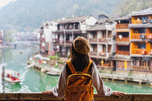 Young female tourist looking at the beautiful landscape of Feng Huang Ancient Town, The famous tourist destination at Hunan Province, China © Kittiphan