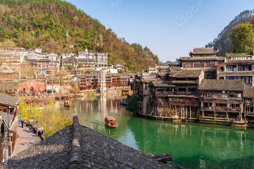 Feng Huang Ancient Town (Phoenix Ancient Town) and tourist boats on Tuo Jiang River, The famous tourist destination at Hunan Province, China © Kittiphan