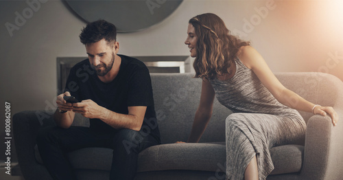 Photos Couple, phone and spy for relationship, cheating and trust with toxic partner in house on sofa