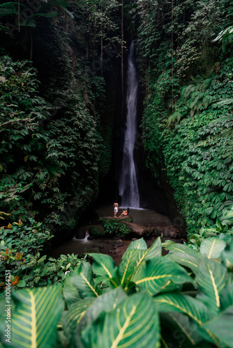 Young couple tourism enjoying the Leke Leke waterfall at Bali in Indonesia